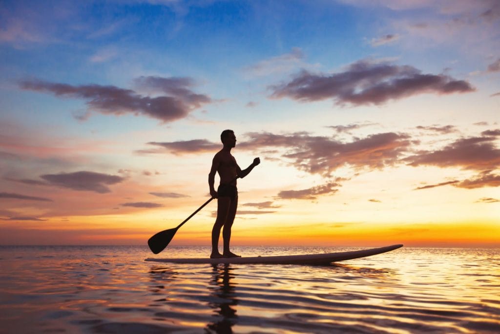 man paddling during sunset 1024x683
