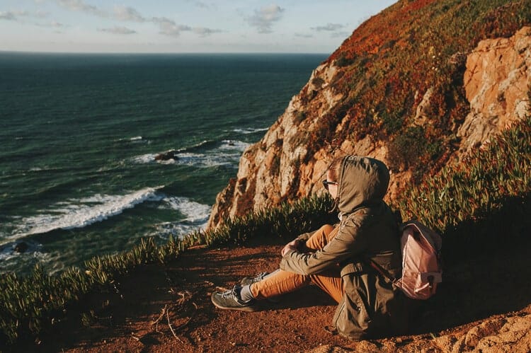 Mujer disfrutando de las vistas en un acantilado en la costa de Lisboa