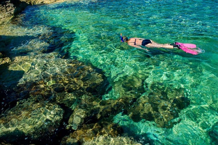 Woman in Bikini Snorkeling through Turquoise water