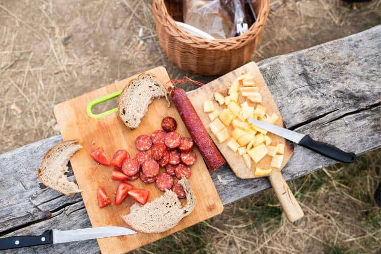 Cortando embutido para comer en un camping