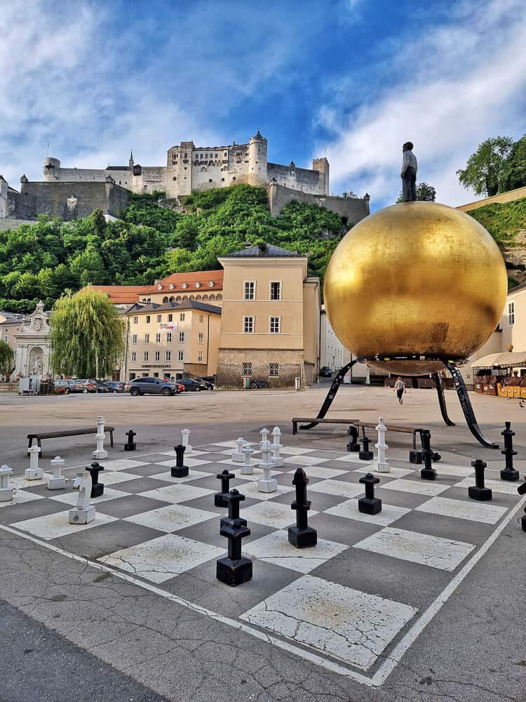 Kapitelplatz con la esfera dorada el tablero de ajedrez y la Fortaleza de Salzburgo de fondo